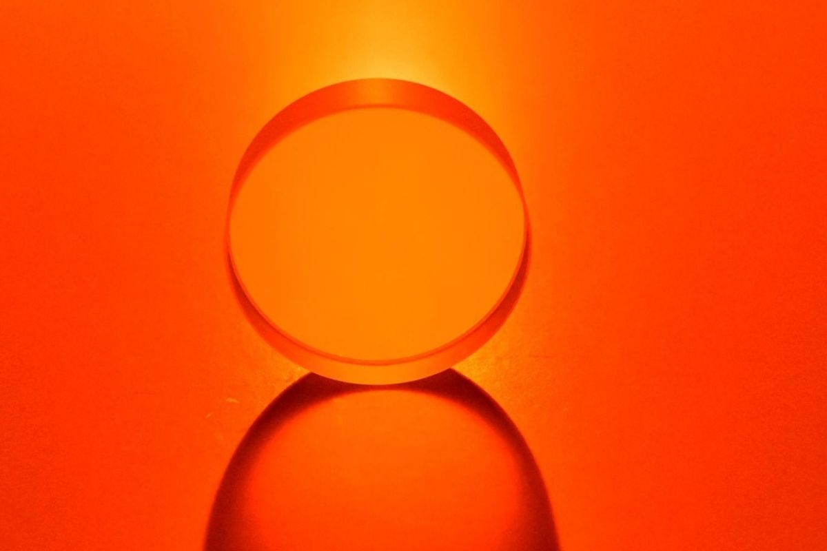 Clear circular object on a bright orange background